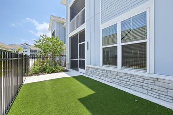 A white house with a black fence and a green lawn.